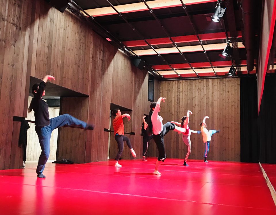 Personas bailando en una sala de ensayos